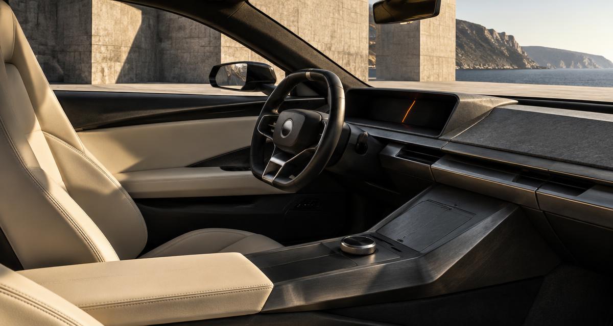 A precise modern grand tourer cockpit in a concrete coastal setting